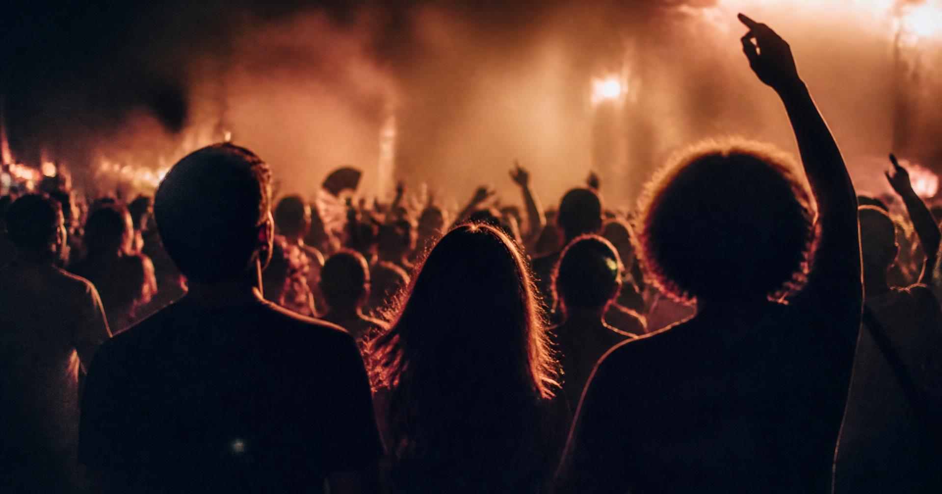 Silhouettes of a crowd at an outdoor evening event